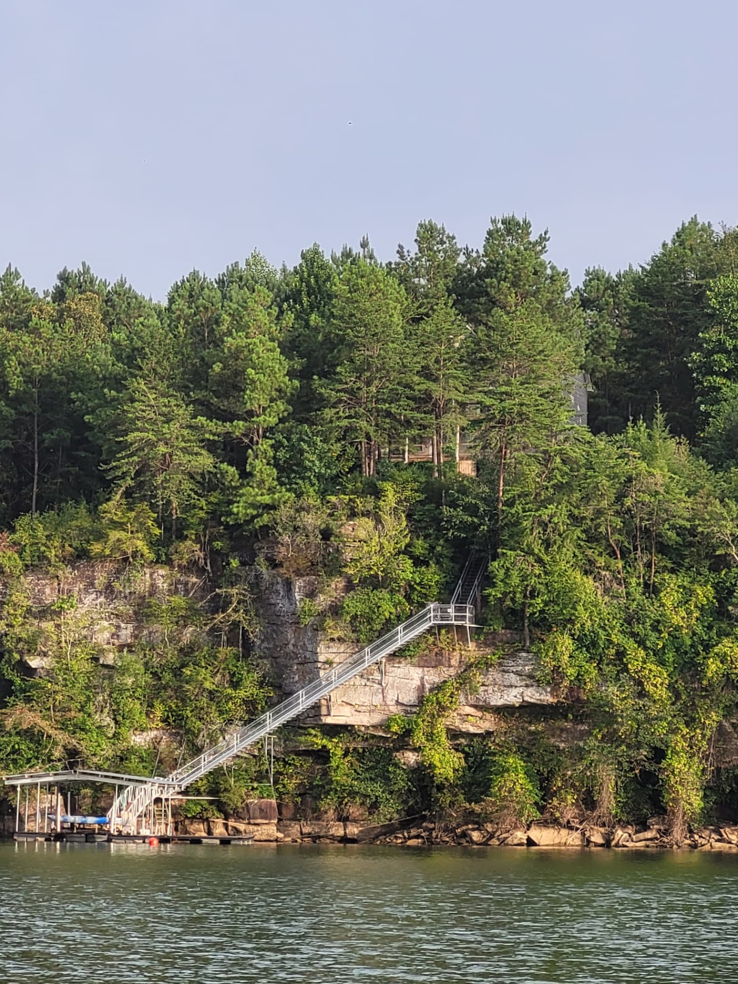 Boat dock at the base of a cliff with a long staircase at Highland Shores